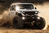 Baja Designs Squadron 2.0 LED light pods mounted on Jeep Rubicon driving through rocky terrain at night