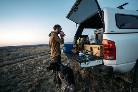 Man drinking coffee with dog keeping watch.